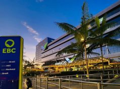 Participação social na EBC: conheça os candidatos do FNDC A imagem mostra, ao fundo, a fachada do edifício Venâncio Shopping, onde fica localizada a sede da Empresa Brasil de Comunicação, a EBC. Do lado esquerdo, em primeiro plano, uma placa vertical instalada na calçada com o logotipo da EBC sobre um fundo azul escuro. O logotipo é verde claro sobre um fundo azul escuro. Abaixo do logotipo, está escrito em letras brancas Agência Brasil, Rádio MEC, Radio Nacional e TV Brasil. Na legenda da foto, está o crédito do fotógrafo: Rafa Neddermeyer/Agência Brasil.